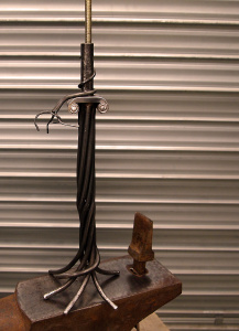 Lampe en ferronnerie et ciselure sur acier au niveau du chapiteau